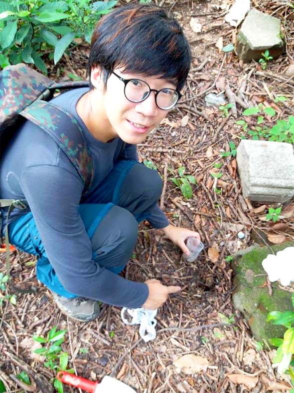 昆蟲學者梁志文在青州山上採集標本。