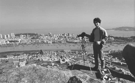1986 從這年開始，漢哥差不多每月都到灣仔山拍攝澳門，當時在遠處的氹仔還未被「大開發」