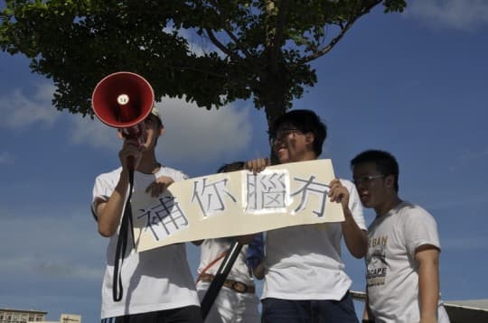 525遊行中，有參與者手持粗口諧音的示威標語。
