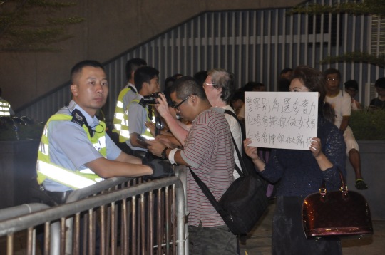 有香港市民舉牌希望警察別為選委效力，但警察沒有理會。