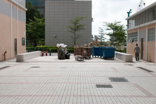 現場可見載有生活垃圾的大型垃圾桶，擺放在路口上，待垃圾車前來收集。