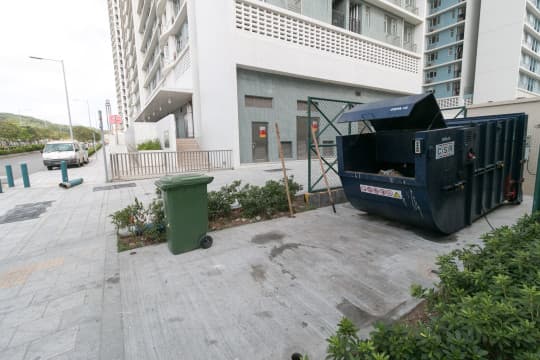 鄰近居雅大廈的業興大廈，其壓縮式垃圾桶放置在大廈外圍。