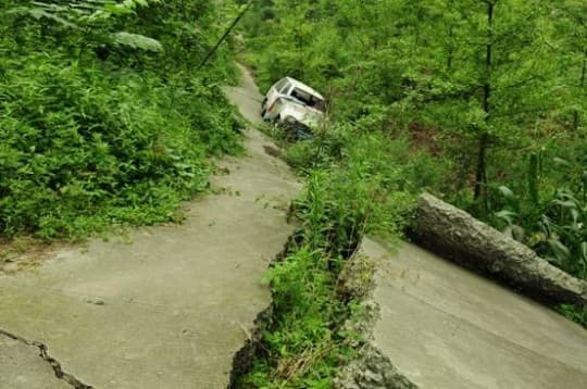 汶川地震時沿水磨-廟子坪斷裂的同震地表破裂之二，深溪溝被掀斜的公路（圖片提供：范曉）。