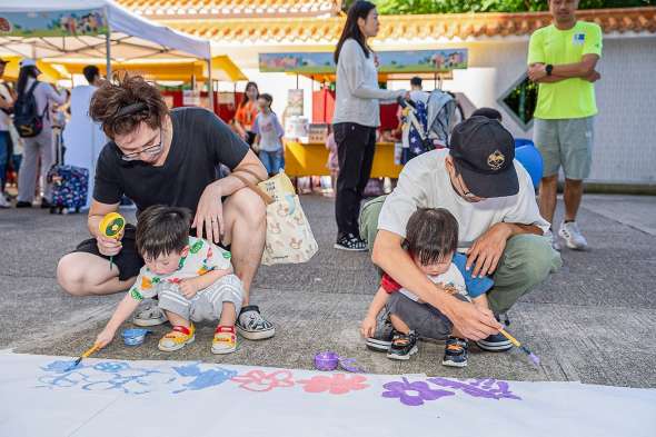 家長與孩子一齊作畫。圖片來源：新聞局