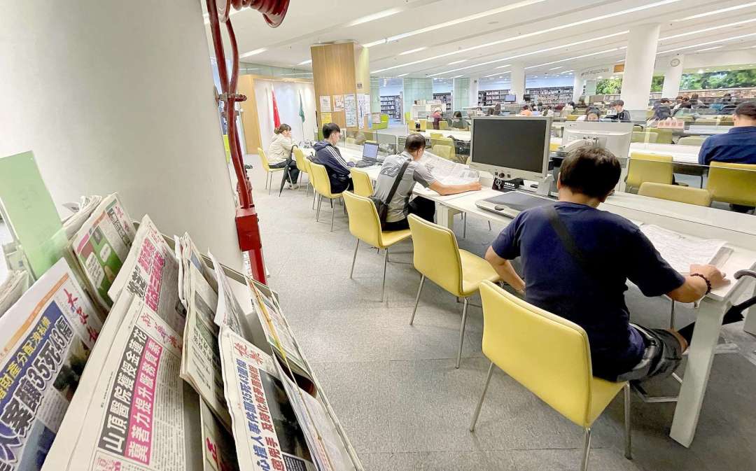 市民在圖書館閱報。